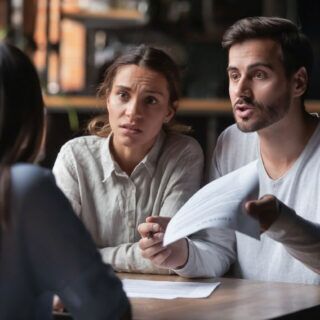 Frustrated couple reviewing legal paperwork after lawyer dropped their car accident case in Texas